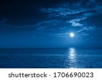This photo illustration of a deep blue moonlit ocean and sky at night  would make a great travel background for any travel or vacation purpose.