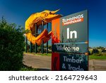 Small photo of West Ballina, New South Wales, Australia - May 28, 2022: Bunnings sign with the giant prawn sculpture in the background