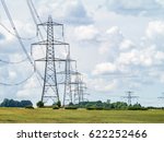 Electricity pylons going into the distance over summertime countryside