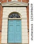 Small photo of Large Georgian blue door with stone surround from an English workhouse. A large Georgian wooden door painted blue with stone surround and fanlight from an English workhouse.