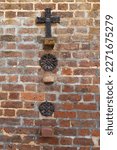 Small photo of Vertical view of old wrought iron decorative cross and anti-earthquake and hurricane rod gib plates on brick wall, Charleston, SC, USA