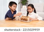 Small photo of Asian sibling eating multigrain whole whet homemade bread and drink milk together with happy moment. Concept of healthy food and lifestyle, nutrition, natural food for children in family life.