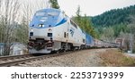 Small photo of Index, WA, USA - January 16, 2023; Amtrak Empire Builder sleeper train travelling around a bend in winter