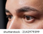 Small photo of Professional barber doing threading procedure and correcting shape of eyebrows to young male client with tweezer in barber shop. Barber at work. Brow care concept. Plucking brows.