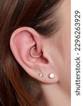 Small photo of piercings on an ear. Conch and helix piercings close up