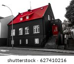 Facade of a black house with a vibrant red roof and doors in the old town of Reykjavík, Iceland. Exterior view of a Nordic downtown neighborhood building. Traditional Icelandic architecture.