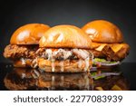 Homemade burgers on dark background.