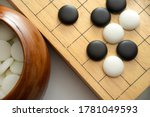 Small photo of top view of weiqi-baduk-igo board game (This is an adversarial game with the objective of surrounding a larger total area of the board with one's stones than the opponent)