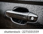 Car door left handle with keyless go sensor. Automatic opening of a car door without a key. The exterior design of a new black luxury car. Closeup.