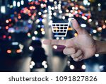 Shopping cart icon on finger over blurred colourful night light city with cars, Shop online concept