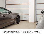 Home garage for two vehicles interior. Clean luxury cars parked at home. Automatic remote control doors. Transport roofed storage