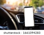 Modern smartphone device gadget mounted on phone holder at car dashboard. Mock-up white screen isolated template. Copyspace for text . Vehicle interior cockpit view. Traffi jam info app