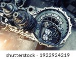 Closeup disassembled car automatic transmission gear part on workbench at garage or repair factory station for fix service or maintenance. Vehicle part detail. Complex industrial mechanism background