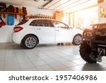 Home suburban countryside modern car and ATV double garage interior with wooden shelf, tools and equipment stuff storage warehouse indoors against sun light. Vehicle parked house parking background