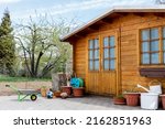 Small beautiful wooden house shed or storage hut for garden tools equipment and bicycles at backyard at beautiful american or european countryside backyard. Cozy rural yard stuff warehouse.