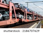 Small photo of Mane new modern electric and fuel cars transportation by cargo freight train railway wagon. Railroad export and import automotive logistics service. Safety and insurance goods shipping insdustry