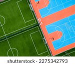 Small photo of aerial view of a green football field and a colorful basketball court, providing a glimpse of two different sports facilities side by side.