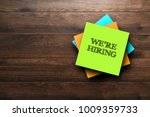We're Hiring, the phrase is written on multi-colored stickers, on a brown wooden background. Business concept, strategy, plan, planning.