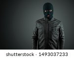 Small photo of Robber, thug in a balaclava on a black background. Robbery, hacker, crime, theft. Copy space