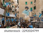 Small photo of Naples, Italy - 04 21 2023: Murals of Diego Armando Maradona with the Napoli shirt located in the Spanish quarters, in the historic center of the city. There are so many people and tourist visiting.