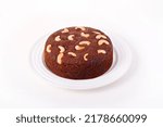 Small photo of Plum cake with cashew nuts on a white plate