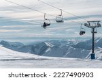 skiers and snowboarders on ski lift at winter at resort