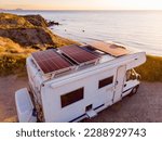Aerial view. Caravan with solar photovoltaic panels on roof camping on cliff sea shore. Mediterranean region of Villaricos, Almeria, eastern Andalusia, Spain.