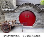 Small photo of Xian,Shanxi,China.August 17,2015.A wooden cart by an ancient red roudn door inside Xi’an Circumvallation with cracks on it in Shanxi province China.