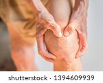 Hands that are holding knees that have problems with the deterioration of the bones of the elderly