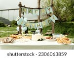 Small photo of catering for the first birthday. inscription, happy birthday. holiday table with food and snacks, holiday table, concept in rustic style, picnic in nature in honor of the birthday