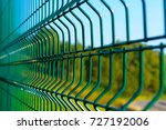 Steel grating fence of soccer field,Metal fence wire with grass in the background