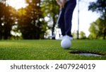 Small photo of Golfers are putting golf in the evening golf course golf backglound. Golfer hitting golf ball. Sport holiday lifestyle Concept.