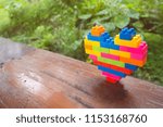 Small photo of Rainbow heart block toy. Is currently on a wooden plate
