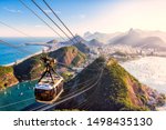 Small photo of Rio de Janeiro/Brazil - August 17th 2019: Aerial View from the Top of Sugar Loaf Mountain (Pao de Acucar) and the famous Cable Car (Bondinho) overlooking the City and the Mountain Range of Rio