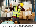 Small photo of Male workers carry heavy rolls of fabric over their shoulders to move them into production and are at risk of injury from lifting too heavy loads many times without weight-lifting equipment.