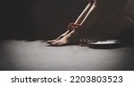 Small photo of Legs of a tortured, rope bound asian woman sit unhappy and despairing in freedom with plates food on the side to survive : Asian women trafficking and illegal immigration.