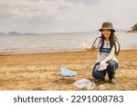 Small photo of Beautiful asian female volunteers picking up plastic waste beach destination with willingness to givethumbs up to help society collect waste recycle reduce global warming and conserve the environment.