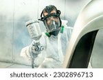 Small photo of Automotive paint services : Male painters who are skilled in using automotive paint sprayers wearing masks to prevent spray paint dispersion work in a closed spray booth for health and quality work.