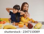 Small photo of Happy mother teaches two young daughters how eat fruits vegetables healthy nutrition while listening but the eldest daughter is deaf and disinterested covering her ears with frowning and touchy hands.