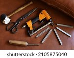 Upholstery tools on brown background, flat layer.