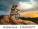 Cyclist Riding the Mountain Bike on the Rocky Trail at Sunset. Extreme Sport and Enduro Biking Concept.