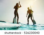 Stand up paddle board couple paddleboarding . Young caucasian couple on summer vacation.