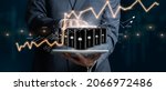 Small photo of Businessman holding a group of barrels of oil with graphs of the stock market as a concept of raw material. Financial world crisis concept. Down of oil price, market decline. 3D Render