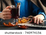 Woman holding mug of hot drink (apple tea, mulled wine). Female hands with cup of seasonal hot drink. Homemade hot fruit tea.