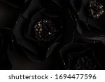 black background with a big flowers with gold shiny glittering, made of paper, top view, macro