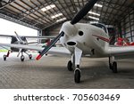 Small private lightweight propeller airplanes in hangar.