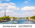 Small photo of Cityscape of Paris, France, with a bateau-mouche cruising on the river Seine, the Alexandre III bridge, the Eiffel tower on the left and the Chaillot palace in the distance by a sunny summer day.