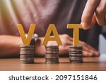 Small photo of Vat Concept. Word vat with stacked coins and the hands are word vat into the jar to accumulate money for paying vat.