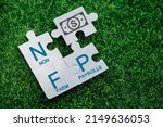 Small photo of Nonfarm Payrolls - key economic indicator. Natural Family Planning concept. Nonfarm Payrolls on jigsaw puzzles on a green artificial grass background.