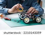 Small photo of Technology of robotics programing and STEM education concept. Science, Technology, Engineering and Mathematics education. Asian teenager doing robot project in science classroom.